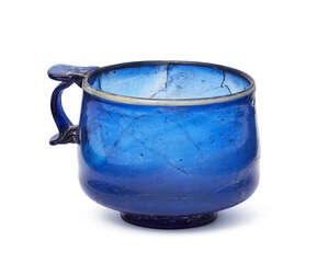 
	
		A Roman cobalt blue glass cup, 1st century AD, of squat form, with ring foot, with white...