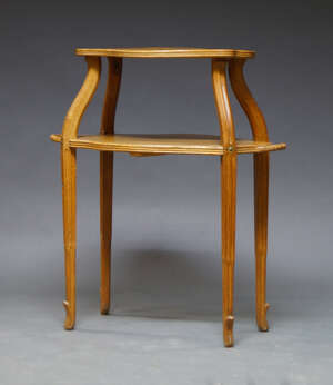 
	
		An Art Nouveau elm and oak two tier étagère, early 20th Century, with two shaped...