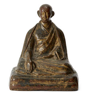 
	
		A Tibetan parcel gilt bronze figure of a monk, 17th/18th century, cast seated wearing...