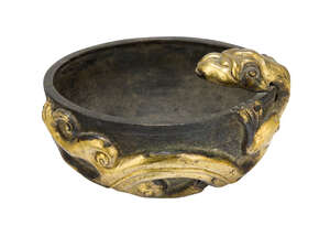 
	
		A Chinese silvered metal Tang style bowl, applied to the rim with a gilt repousse...