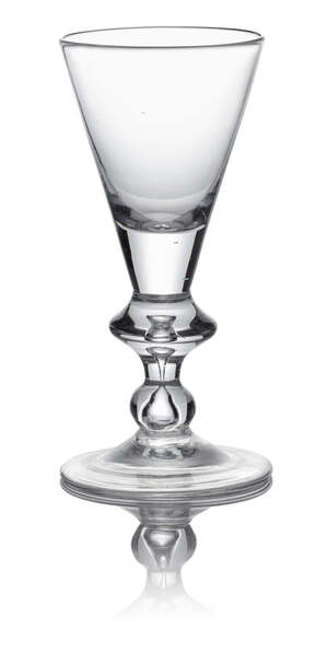 A Queen Anne heavy baluster glass, c. 1710, with conical bowl above a teared angular knop, the tear continuing to a basal true baluster knop, on circular foot,