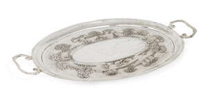 
	
		An Indian white metal twin-handled oval tray, the base decorated with repousse village,...