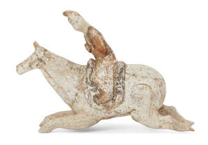 A Chinese miniature pottery figure of a polo player, Tang dynasty, in full gallop, painted in white slip with pigments to saddle and bridle, and rider's ja