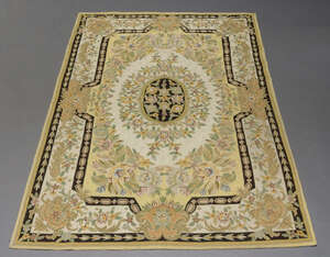 
	
		Two crewelwork carpets, mid-20th century, each decorated with a central floral panel on a...