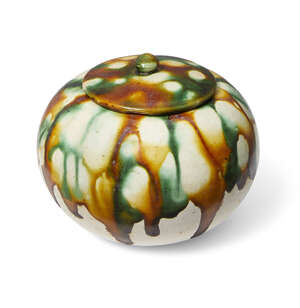 A Chinese sancai-glazed ovoid jarlet and cover, Tang dynasty, splashed to the cover and body in amber, cream, and green glaze stopping unevenly above the base,