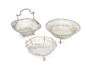 A pierced silver basket, London, c.1913, the Goldsmiths and Silversmiths Co., of rounded square form, with pierced sides and a fixed, curving handle, 17.7cm di