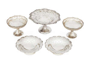 A pierced silver bonbon dish, Birmingham, c.1904, William Aitken, raised on a circular foot, with shell and scroll rim, together with a further four smaller bo