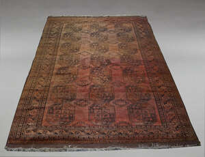 
	
		An Afghan carpet, mid 20th Century, with three rows of octagonal panels in a deep red...