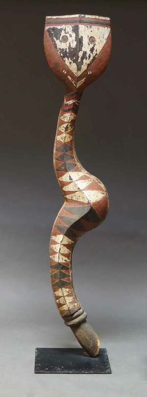 
	
		An African Baga snake sculpture, decorated with brown, black and white geometric...