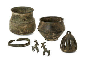 A group of Luristan bronze objects,  12th-8th century B.C., North West Iran, comprising a bronze armlet formed of ribbed band with deer finials, two bronze pen