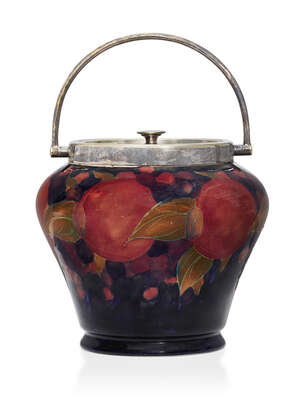 
	
		William Moorcroft (1872-1945), a Pomegranate pattern biscuit barrel with plated cover...
