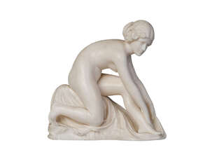 
	
		A carved ivory figure , c. 1920, unsigned, carved as a naked young woman, kneeling and...