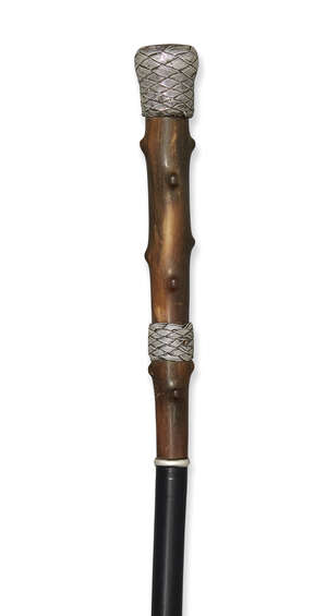 
	
		A silver-mounted horn walking cane, c.1920, with basket-weave grip and collar, the top...