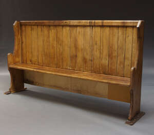
	
		A pine church pew, first half 20th Century, with high slatted back on shaped end...