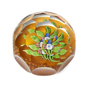 A French glass paperweight, in the style of Baccarat, with an octagonal indented body and...