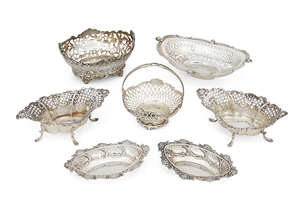 A group of seven Victorian and later pierced bonbon dishes, the largest, c.1900 with scalloped rim and putti mask points, 20cm long, one dish with articulated 