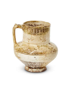 
	
		A small intact Kashan lustre-glazed jug with inscriptions, Iran, late 12th century, on a...