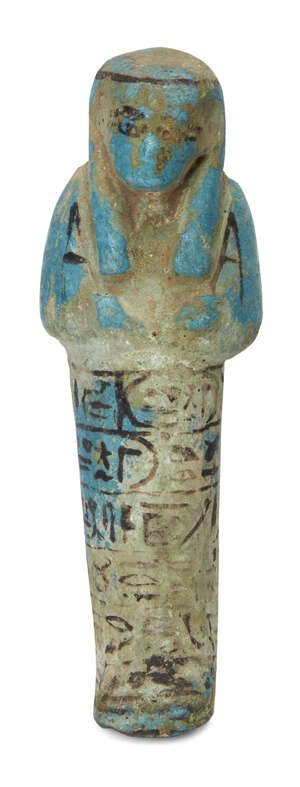 An Egyptian bright blue glazed composition shabti of typical form with black glazed details, holding two hoes, wearing the seshed fillet and a seed-bag across 