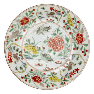 A Chinese porcelain shallow dish, Kangxi period, painted in famille verte enamels to the central reserve with two red-crested cranes, inside a border with alte