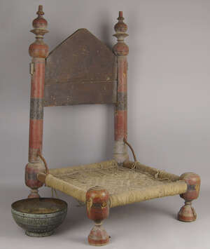 
	
		An Indian wooden and painted low chair, late 19th/20th century, with wooden back...