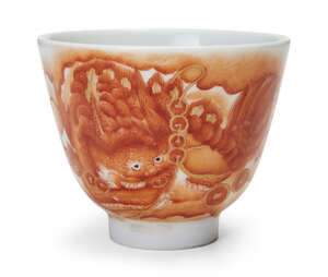 
	
		A Chinese iron red 'lion and cash' cup, Tongzhi seal mark, 20th century, 7.7cm diam.
		
