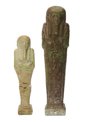 
	
		Two Egyptian green glazed composition shabtis carrying a pick and hoe, one of dark green...