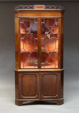 
	
		An Edwardian mahogany corner cupboard, the top with pierced fretwork cornice, above two...