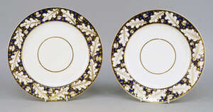 
	
		A pair of Bloor Derby plates, 19th century, with gilt oak leaves to the rim on blue...
