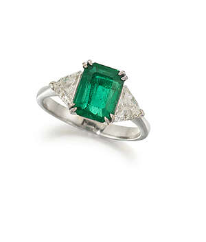 
	
		An emerald and diamond three stone ring, the rectangular claw-set emerald in claw-set...