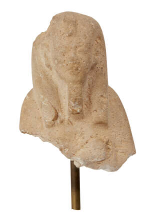 A yellow quartzite upper section of a shabti of Akhenaten clutching an ankh hieroglyph in the remaining left hand, wearing the tripartite wig with frontal urae