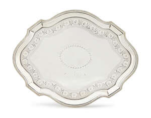A George III silver teapot stand, London c.1791, Peter & Ann Bateman, of oval serpentine form with bright cut engraving and central vacant cartouche, upon four