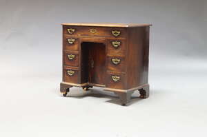 
	
		A George III mahogany kneehole desk, the rectangular top above an arrangement of seven...
