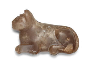 A carved agate cat weight, possibly Mesopotamian, shown crouching with ear pricked forward, the tail moulded to the body, delineated eyes, 5.8cm. long x 3.7cm.