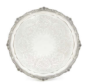 A Victorian Scottish silver salver, Edinburgh c.1898, Hamilton & Inches, with gadrooned and shell border and engraved decoration, raised on four decorative lio
