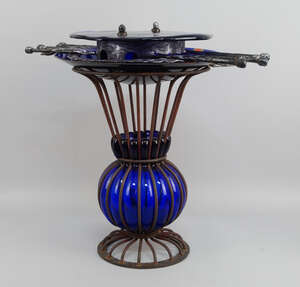A blue glass and worked steel wall light, 20th century, 52cm high, together with a wrought iron and blue glass vase and a Picasso taste enamel plate decorated 