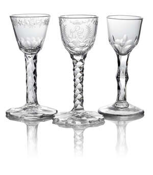 A George III drinking glass, the bowl engraved with crowned entwined initials within palm leaves, with swags of stars to the rims, on facetted stems, with cut 