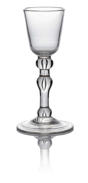 A George II balustroid wine glass, c. 1740, with round funnel bowl above teared shoulder, medial and basal knops, on domed circular foot, 14.5cm high