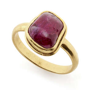 
	
		A ruby-set gold ring, South India, in a modern gold setting, the polished pebble stone of...