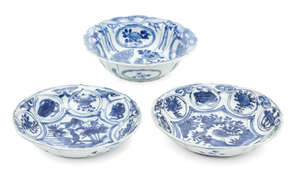 Two Chinese porcelain Kraak small dishes and a similar bowl, 17th century, each painted in underglaze blue with birds amongst foliage and panels of fruit and a