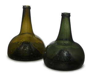 
	
		Two similar Dutch green glass wine bottles, 18th century, of squat form with inset...