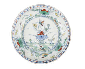 A Chinese porcelain doucai 'lotus pond' dish, Kangxi, the interior delicately enamelled with a flying duck and ducks swimming in a lotus pond, inscribe