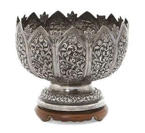 
	
		An Indian silver bowl, raised on a wooden stand to a circular foot, the body chased with...