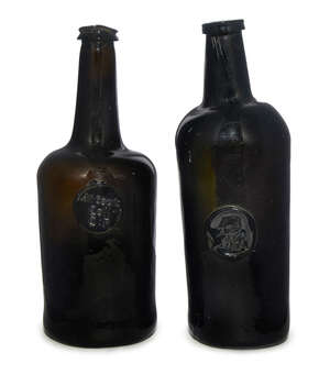 
	
		Two seal dark brown green glass wine bottles, mid/ late 18th century, one with elongated...