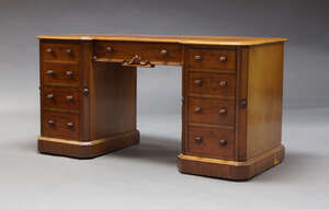 
	
		A Victorian mahogany knee hole desk, the inverse breakfront top, above an arrangement of...