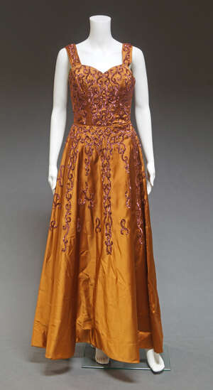 
	
		A 1960s bronze evening gown, decorated with bronze sequins, together with four further...