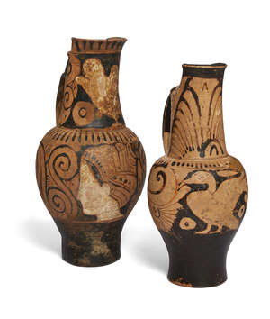Two Faliscan red-figure beak-spouted oinochoai, circa 4th Century B.C., comprising an oinochoe decorated with a profile female head wearing a kekryphalos and r