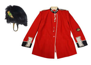 
	
		A Welsh Guards bearskin and tunic, 20th century, the bearskin with brass chin scales and...