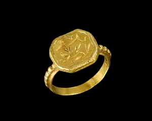 A gold ring with inscribed bezel,
The band plain, the rectangular flat bezel engraved with...
