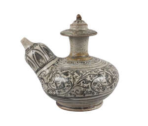 A Sawankhalok stoneware kendi, 15th century, painted in underglaze blue with foliate scrolls, bears Bluett label to base, 14cm high