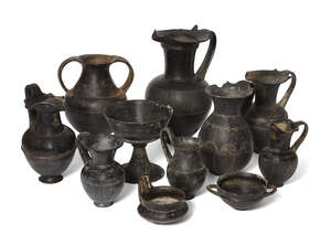 A group of eleven Etruscan bucchero ware vessels, circa 7th-6th Century B.C., comprising a large oinochoe, a spur on either side of the strap handle, a band of